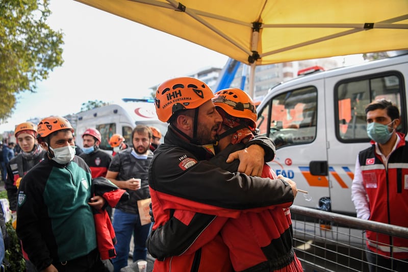Ahmet Celik (R) and Ibrahim Topal (L) from Turkey's Humanitarian Relief Foundation (IHH) rescue and search team embrace after rescuing Ayda Gezgin, a three-year-old survivor from a collapsed building in Izmir on November 3, 2020, following a 7.0-magnitude quake which struck the Aegean port city on October 30. - Rescue workers were searching eight buildings in Izmir despite dwindling hope for survivors. The death toll from the quake rose to 102 in Turkey on November 3, the Turkish emergency authority AFAD reported, with 1,026 people injured of which 147 remain in hospital. (Photo by Ozan KOSE / AFP)