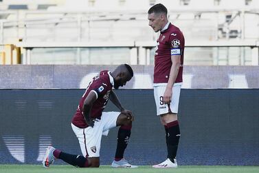 Torino's Nicolas Nkoulou, left, kneels as he celebrates with his teammate Andrea Belotti after scoring his side's opening goal, during the Serie A soccer match between Torino and Parma, at the Olympic Stadium in Turin, Italy, Saturday, June 20, 2020. Serie A restarts Saturday following the easing of restrictions due to the COVID-19 pandemic, with matches being played without spectators because of the coronavirus lockdown. (Fabio Ferrari/LaPresse via AP)
