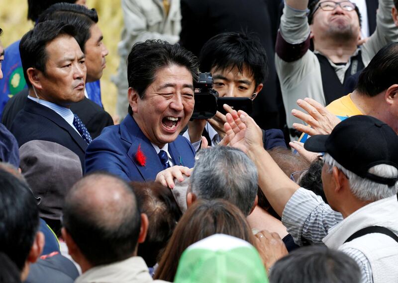 Japan's Prime Minister Shinzo Abe shakes hands with his supporters after an election campaign rally in Fukushima in 2017. Reuters