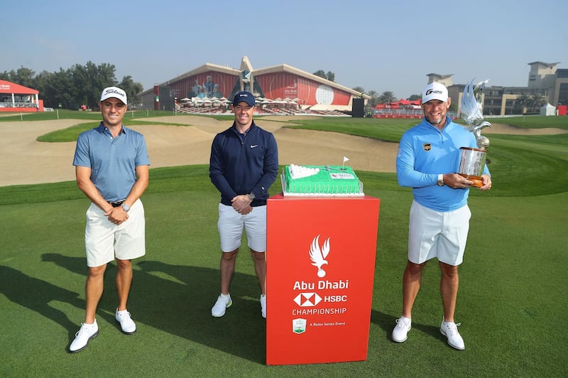 ABU DHABI, UNITED ARAB EMIRATES - JANUARY 19: (L-R) Justin Thomas of the United States of America, Rory McIlroy of Northern Ireland and Lee Westwood of England pose for a photograph with a cake to celebrate the 50th Anniversary of the UAE during practice ahead of the Abu Dhabi HSBC Championship at Abu Dhabi Golf Club on January 19, 2021 in Abu Dhabi, United Arab Emirates. (Photo by Warren Little/Getty Images)