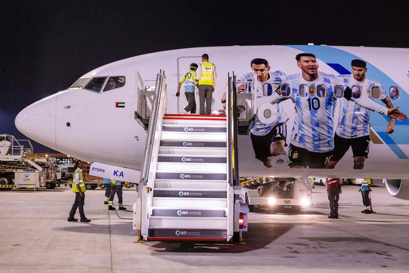Members of the Argentina team peer out from the windows on their plane. AFP