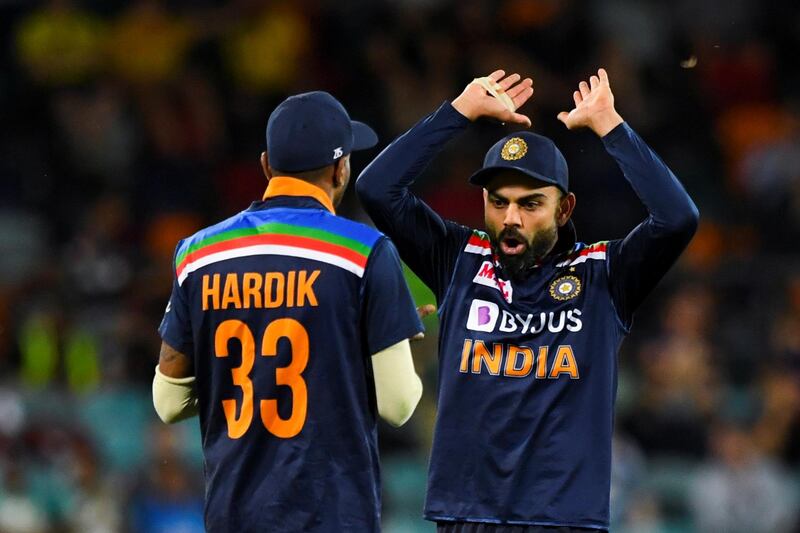 Virat Kohli of India (R) celebrates with teammate Hardik Pandya of India after claiming the wicket of Aaron Finch of Australia during the first T20 cricket match between Australia and India at Manuka Oval in Canberra, Australia, December 4, 2020.  AAP Image/Lukas Coch via REUTERS  ATTENTION EDITORS - THIS IMAGE WAS PROVIDED BY A THIRD PARTY. NO RESALES. NO ARCHIVE. AUSTRALIA OUT. NEW ZEALAND OUT