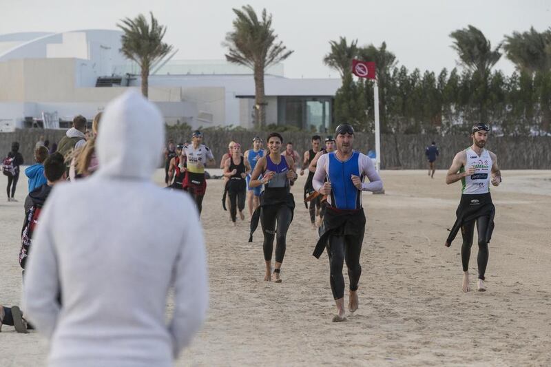 DUBAI, UNITED ARAB EMIRATES, 29 JANUARY 2016. The Ironman 70.3 Dubai Triathlon held on Sunset Beach next to the Burj Al Arab. Contestants run along the beach to the cycle exchange point. (Photo: Antonie Robertson/The National) ID: None. Journalist: None. Section: Sport.