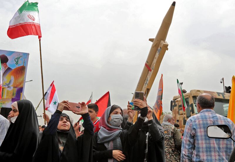 Iranians march next to a Kheibar missile during a rally in Tehran. AFP