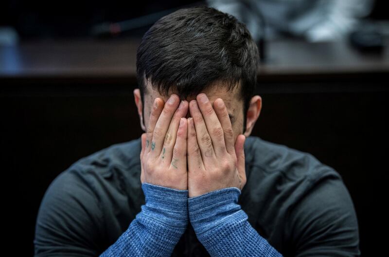 Twenty-two-year-old Iraqi Ali B. covers his face at the start of his trial in Wiesbaden, Germany, March 12, 2019. Ali B. was arrested by police in the Kurdistan region of Iraq and is accused of murdering and raping Susanna F., a 14-year-old German girl.     Boris Roessler/Pool via Reuters