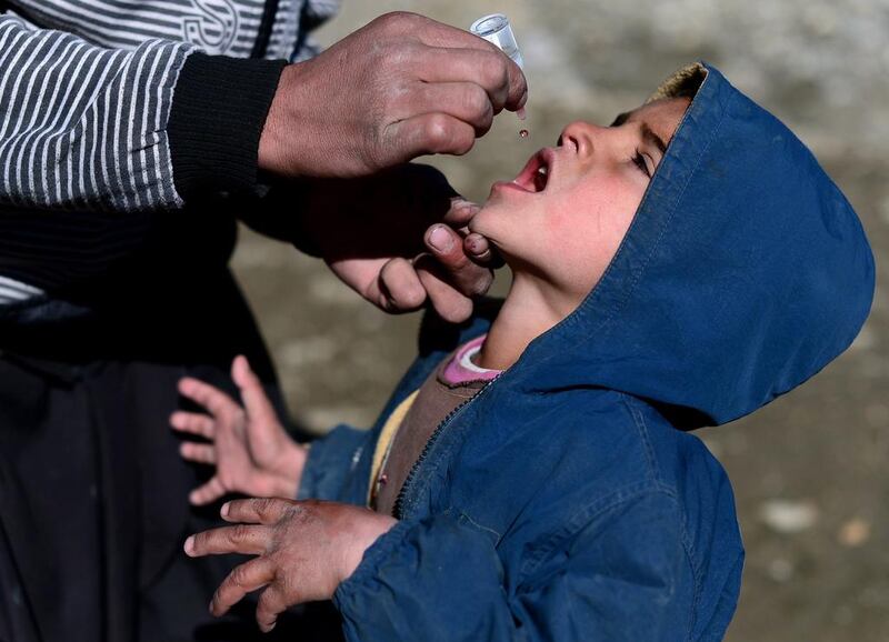 An Afghan health worker administers polio vaccine drops to a child in Kabul on February 11. Afghanistan launched an emergency polio vaccination campaign in Kabul after a girl contracted the disease, the city's first case since the Taliban were ousted in 2001. Wakil Kohsar / AFP