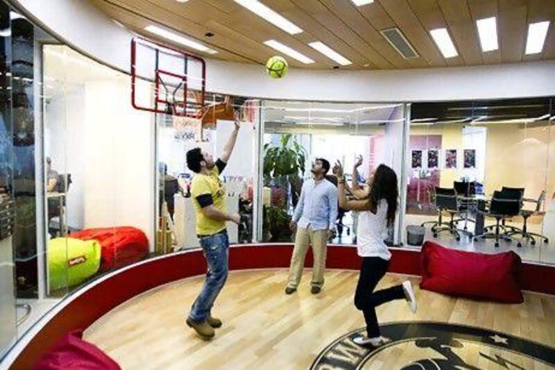 From Left, Conan Gregory, account executive, Waqas Paracha, account manager, and Zaina Nasser, account executive, play a game of basketball at the TBWARAAD MENA region office. Sarah Dea / The National