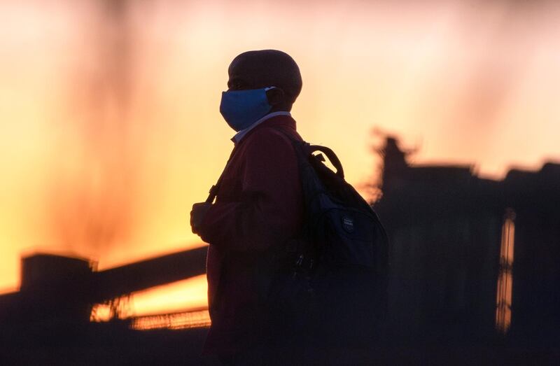 A man wearing protective masks to help curb the spread of the coronavirus walks back home from work in Germiston, near Johannesburg, South Africa. AP Photo