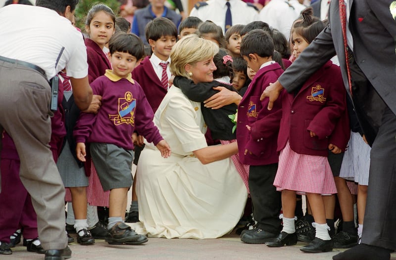 GREAT BRITAIN - JUNE 06:  Diana, Princess of Wales crouching down to embrace a pupil at the Shri Swaminarayan Mandir in Neasden  (Photo by Tim Graham Photo Library via Getty Images)