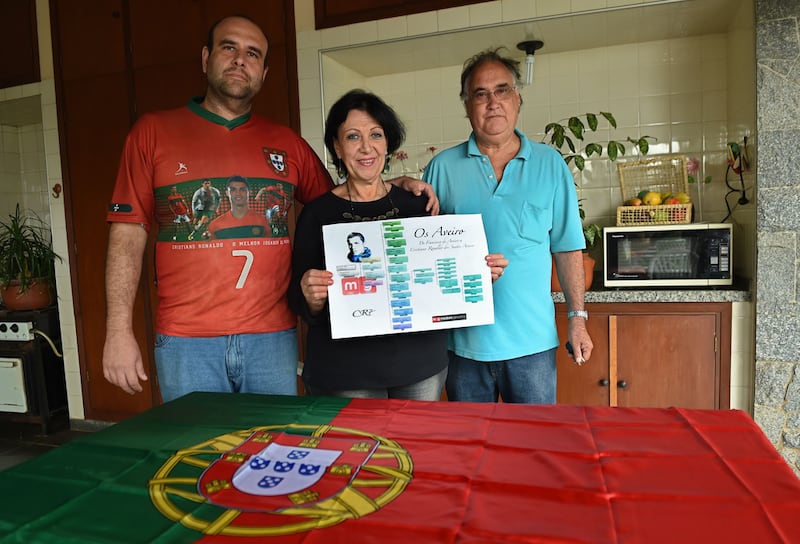 Rogers Aveiro, left, his mother Sandra, centre, and father Armando display their family tree in Campinas, Brazil. The younger Aveiro claims to be a distant relative of Portugal’s Cristiano Ronaldo dos Santos Aveiro. Philippe Desmazes / AFP


