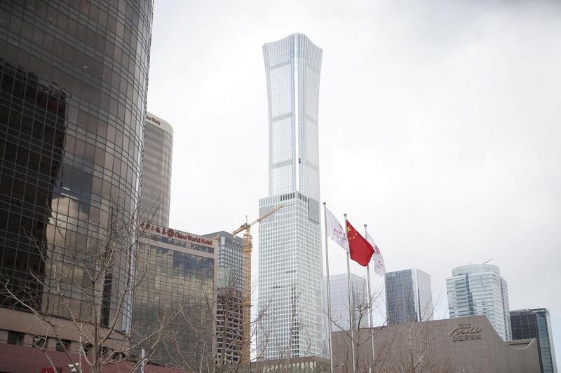 A Chinese flag flies as the CITIC Tower, center, stands in the central business district in Beijing, China, on Thursday, March 14,  China is planning to approve new rules for foreign investment in the country this week, a sweeping overhaul of regulations that will affect corporate titans from Ford to Alibaba andÂ Tencent. Photographer: Giulia Marchi/Bloomberg via Getty Images