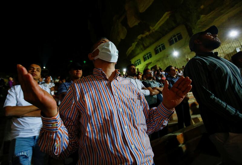 A Coptic Christian wears a mask at Easter midnight mass in the Samaan El Kharaz Monastery in the Mokattam Mountain area of Cairo. Covid-19 cases are on the rise in Egypt. Reuters