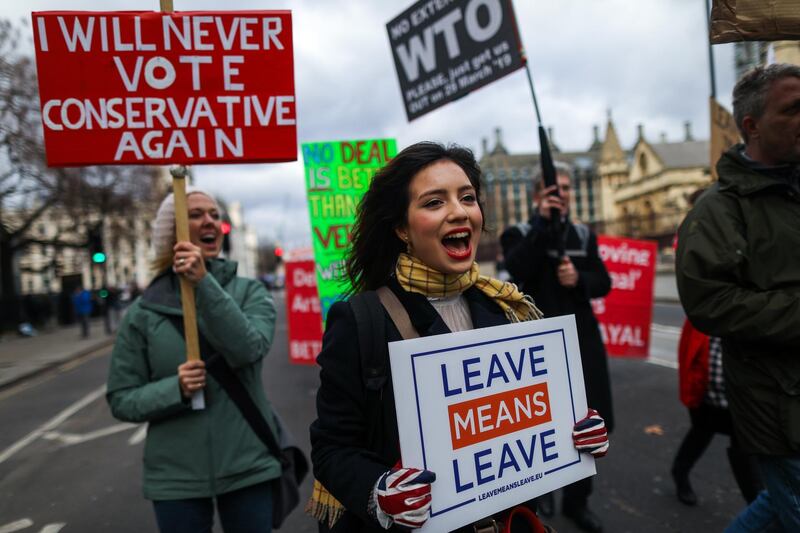 Pro-Brexit campaigners hold placards as they march near the Houses of Parliament in London, U.K., on Wednesday, March 13, 2019. Britain will confront head-on the threat of a no-deal Brexit in a parliamentary vote with huge ramifications for Prime Minister Theresa May. Photographer: Simon Dawson/Bloomberg