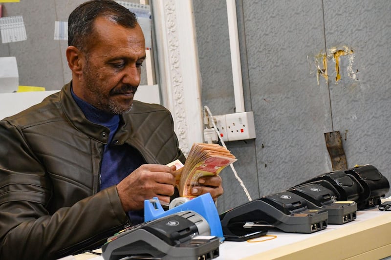 An employee of a currency exchange counter, counts local currency bank notes in the southern Iraqi city of Nasiriyah in the Dhi Qar province. AFP