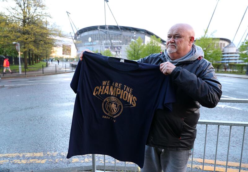 A Manchester City fan holds up a 'We Are Champions t-shirt' at the Etihad Stadium. PA