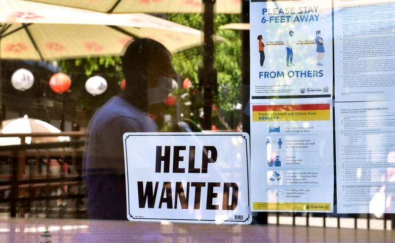 A 'Help Wanted' sign is posted beside Coronavirus safety guidelines in front of a restaurant in Los Angeles, California. Following over a year of restrictions due to the coronavirus pandemic, many jobs at restaurants, retail stores and bars remain unfilled, despite California's high unemployment rate, causing some owners to fear they will not be able to fully reopen by the June 15th date California has given for a full reopening of the economy.  AFP