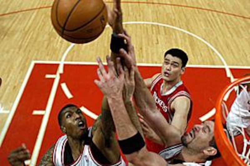 Chicago Bulls Tyrus Thomas, left, Brad Miller and the Houston Rockets Yao Ming contest for a rebound during their NBA encounter.