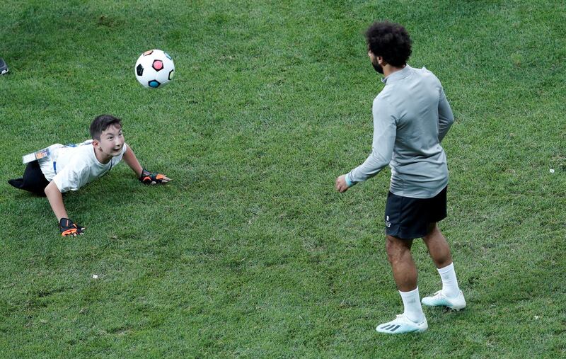 Mohamed Salah plays football with a child during training in Istanbul. Reuters