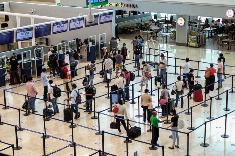 Tourists wait to check in at the airport in Cancun, Mexico. In Quintana Roo state, where Cancun is located, tourism is the only industry there is, and Cancun is the only major Mexican resort to reopen so far. AP Photo