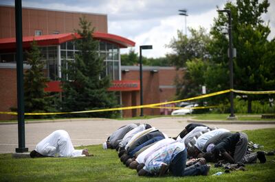 Mohamed Omar, left, the executive director of the Dar Al Farooq Center Islamic Center leads afternoon prayers outside the police tape surrounding the center Saturday Aug. 5, 2017 in Bloomington, Minn.  Bloomington Police and federal authorities are investigating an early morning explosion at Dar Al Farooq Islamic Center. (Aaron Lavinsky/Star Tribune via AP)