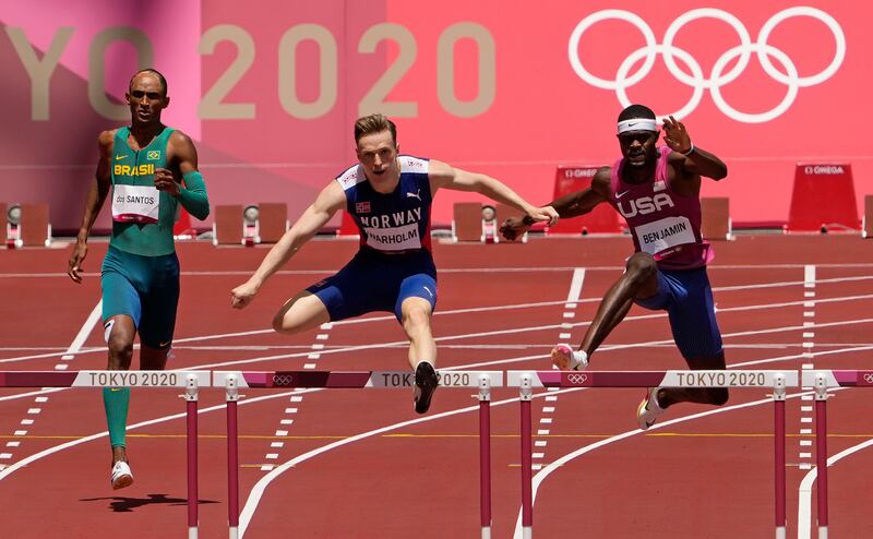 Karsten Warholm, of Norway, centre, clears a hurdle before winning the gold medal ahead of Rai Benjamin, of United States in the final of the men's 400-meter hurdles at the 2020 Summer Olympics.