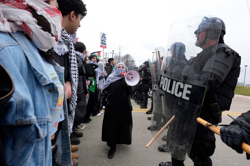 Pro-Palestinian demonstrators face police during a visit by US President Joe Biden to Warren, Michigan. AP