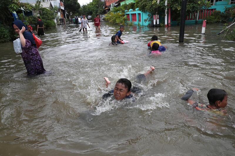 Children play in a flooded neighbourhood in Tanggerang on the outskirts of Jakarta, Indonesia. AP
