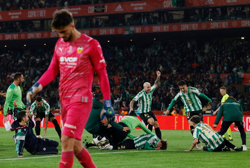 Real Betis players rush to celebrate with Juan Miranda celebrates after scoring a penalty to win the shoot-out and the Copa del Rey. Reuters