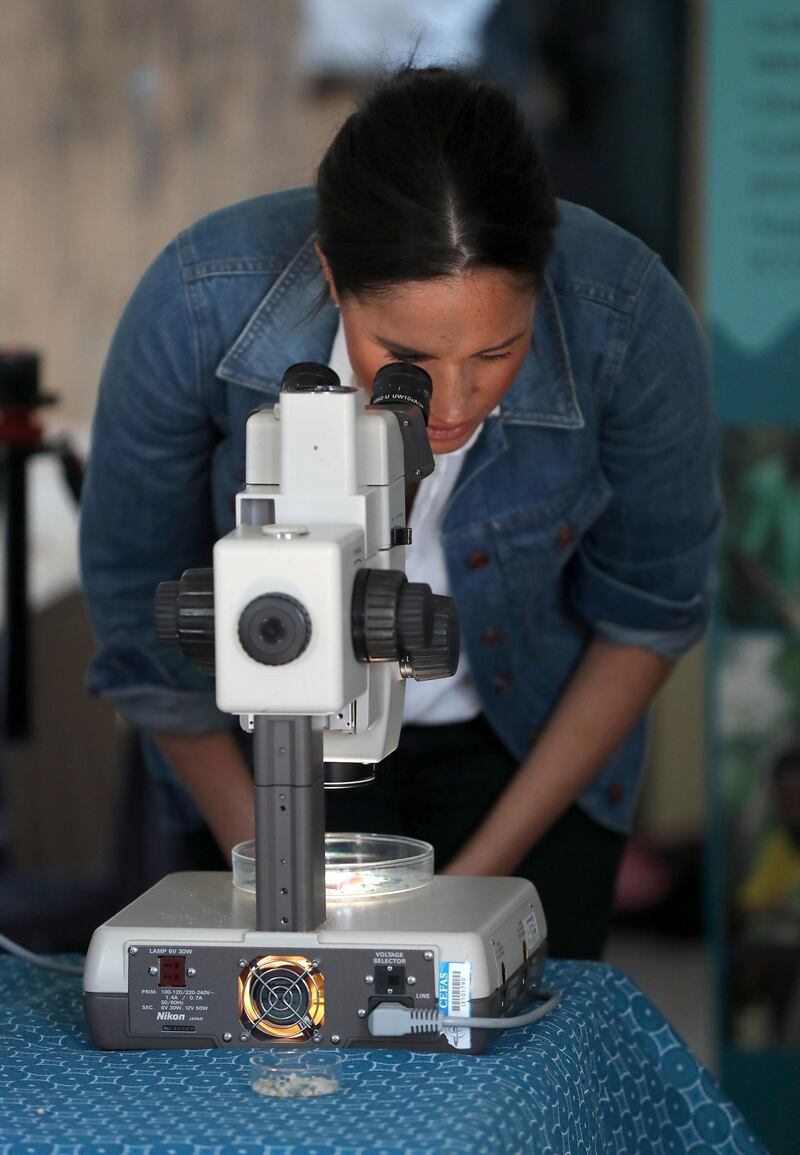 Meghan, Duchess of Sussex looks through a microscope as she visits Waves for Change, an NGO, at Monwabisi Beach with Prince Harry, Duke of Sussex in Cape Town, South Africa. Waves for Change supports local surf mentors to provide mental health services to vulnerable young people living in under resourced communities. Getty Images