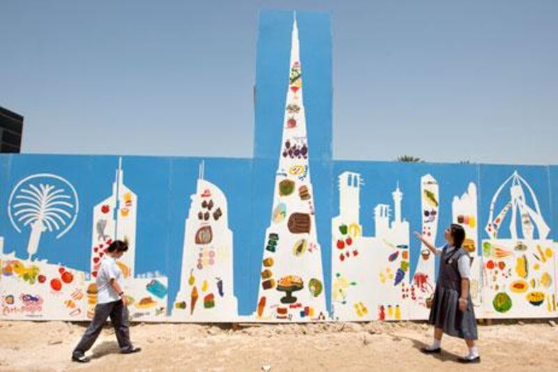 Dubai, United Arab Emirates, May 30, 2013 -  Special needs kid Farheen (right),16, and Maha, 18, stand beside painted barriers they help to create at the AMB building construction site. ( Jaime Puebla / The National Newspaper ) 
