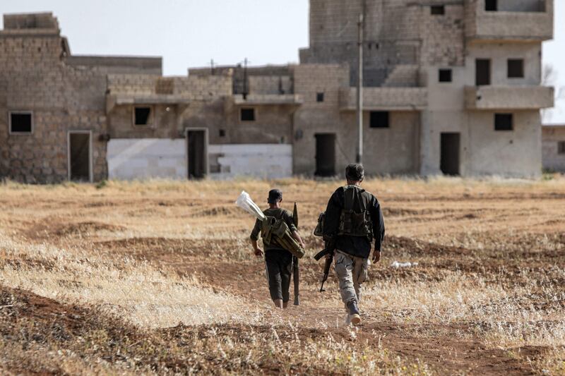 Turkish-backed Syrian rebel fighters walk at a position along the battle frontlines with the Syrian Democratic Forces (SDF) in Syria's northern city of Manbij, in June 2022. AFP
