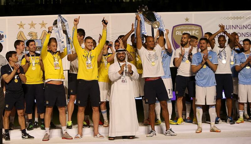 Manchester City captain Vincent Kompany lifts the English Premier League trophy after his team's friendly against Al Ain at the Hazza bin Zayed Stadium on May 15, 2014. Satish Kumar / The National
