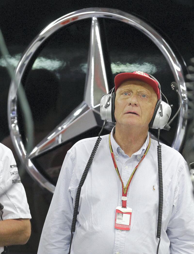 Niki Lauda, Mercedes Formula One team non-executive chairman, looks at screens inside the team's garage during the qualifying session of the Formula One Singapore Grand Prix in Singapore on September 20, 2014.   AFP PHOTO / POOL / TIM CHONG (Photo by TIM CHONG / POOL / AFP)