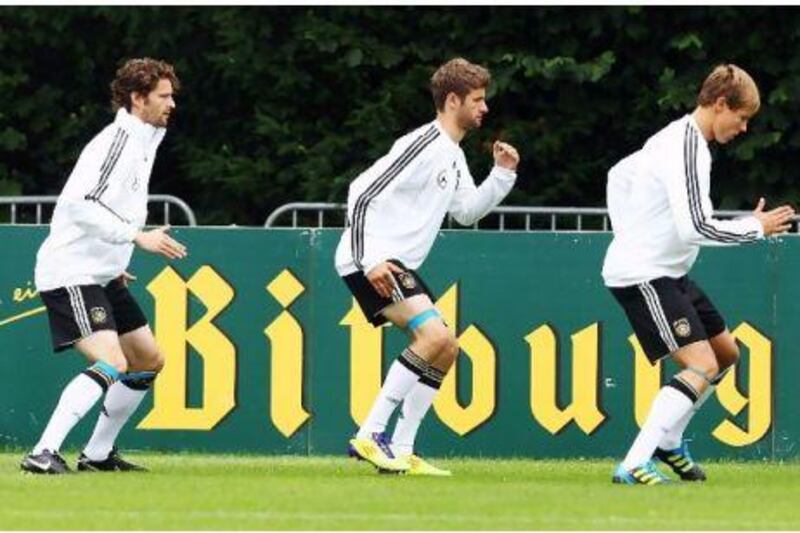 Germany's Arne Friedrich, left, Thomas Muller, centre, and Holger Badstuber take part in training at the team's camp in Frankfurt ahead of tonight's match with Group A rivals Austria.
