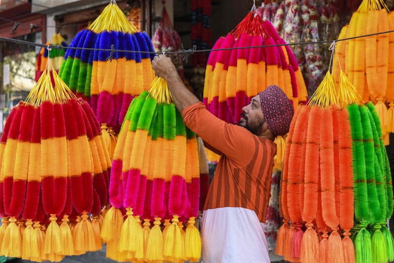 A shopkeeper hangs artificial flower garlands in Amritsar. AFP