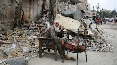 An injured man sits by the ruins of a house in Rafah, southern Gaza, following an Israeli strike. Reuters