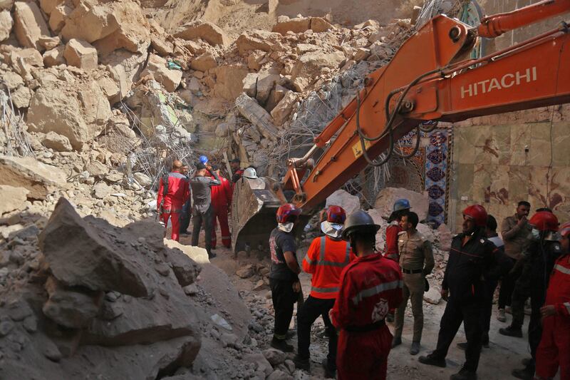 Rescuers remove rubble using a bulldozer in their search for survivors and victims' bodies. AFP