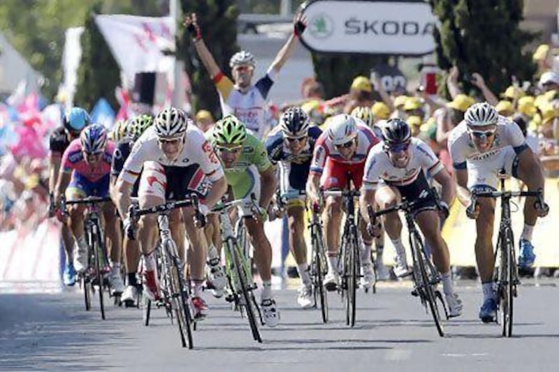 A teammate, rear, starts celebrating after watching Andre Greipel, left in white, sprints towards the finish line ahead of Peter Sagan, in green, to win the sixth stage of the Tour de France in Montpellier. Laurent Cipriani / AP Photo