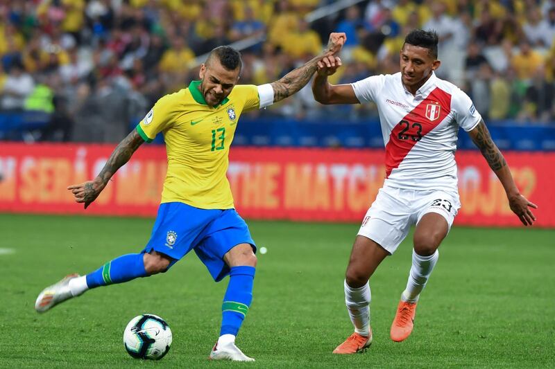 Brazil's Dani Alves is marked by Peru's Christofer Gonzales. AFP