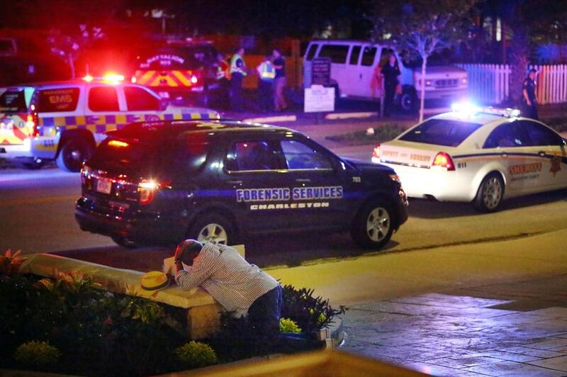 A man kneels across the street from where police gather outside the Emanuel AME church following a 2015 shooting in Charleston, South Carolina. The new Texas law could mean a rise in mass shootings that Americans routinely condemn and yet take for granted. AP Photo