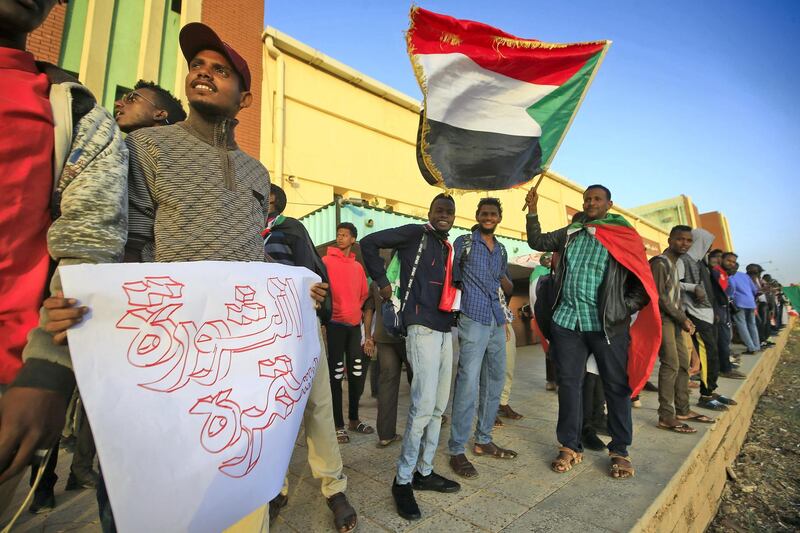 Sudanese protesters wait at a train station in Khartoum to board a train to Atbara on December 19, 2019 to celebrate the one-year anniversary of their protest movement that brought down Omar al-Bashir last April after a thirty-year rule. - A year after demonstrations broke out in Sudan over soaring bread prices, celebrations are planned across the country to mark the uprising that brought down veteran autocrat Bashir. (Photo by ASHRAF SHAZLY / AFP)