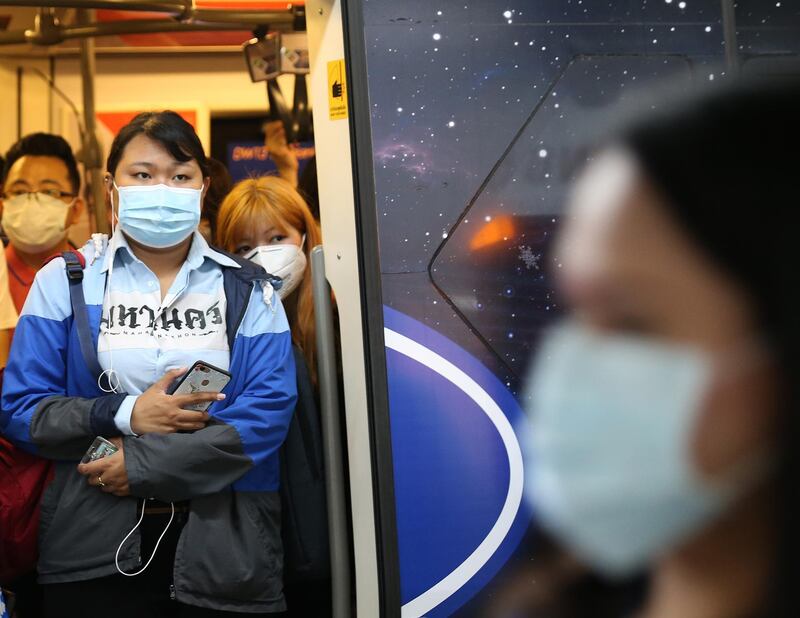 Passengers wear protective masks as they stand within a skytrain coach in Bangkok, Thailand.  EPA