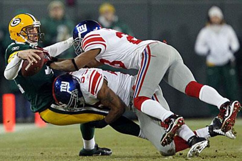 Aaron Rodgers of Green Bay is sacked by New York Giants' Michael Boley, center, and Corey Webster.