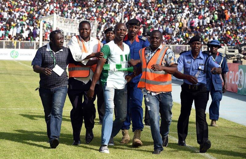 Security officials evacuate a man (C) who tried to hug Nigerian players during the African Cup of Nations qualification match between Egypt and Nigeria, on March 25, 2016, in Kaduna. AFP / PIUS UTOMI EKPEI