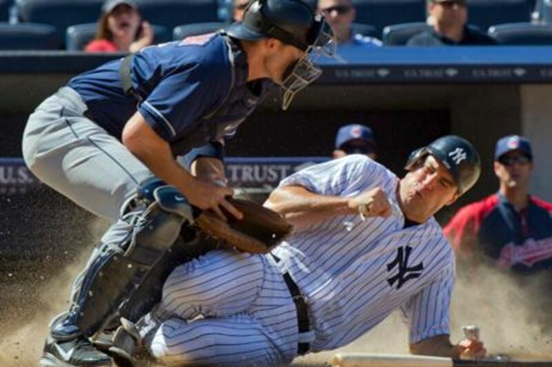 New York Yankees runner Mark Teixeira scores as Cleveland Indians catcher Lou Marson (L) tries to control the ball in the eighth inning of their MLB American League baseball game at Yankee Stadium in New York, June 27, 2012. REUTERS/Ray Stubblebine (UNITED STATES - Tags: SPORT BASEBALL)