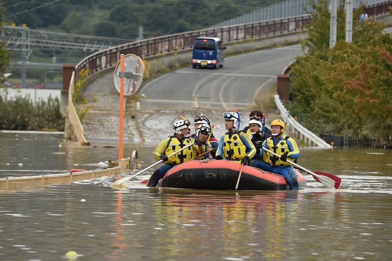 Emergency personnel paddle across floodwaters. AFP