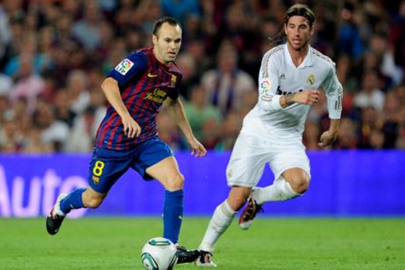 Barcelona's midfielder Andres Iniesta (L) vies with Real Madrid's defender Sergio Ramos (R) during the second leg of the Spanish Supercup football match FC Barcelona vs Real Madrid CF on August 17, 2011 at the Camp Nou stadium in Barcelona.     AFP PHOTO/ JOSEP LAGO