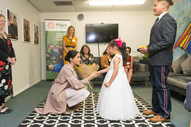 Meghan is presented with flowers from Ghianna Angi during a visit to Pillars, a charity operating across New Zealand that supports children who have a parent in prison, in Manukau City in Auckland. AFP