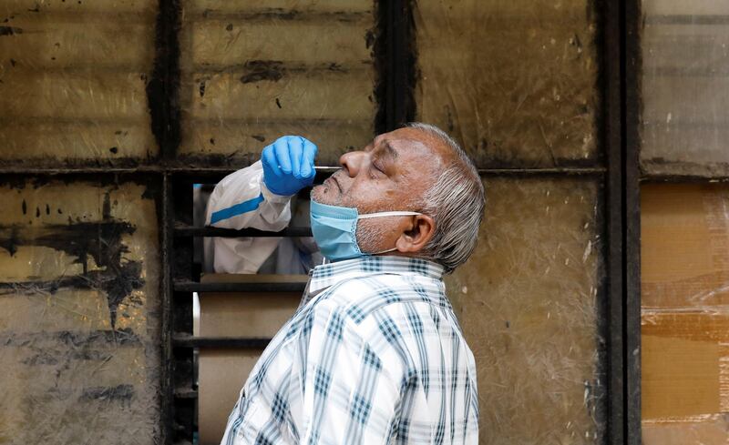 A medical worker collects a sample from a man at a school turned into a centre in New Delhi. Reuters
