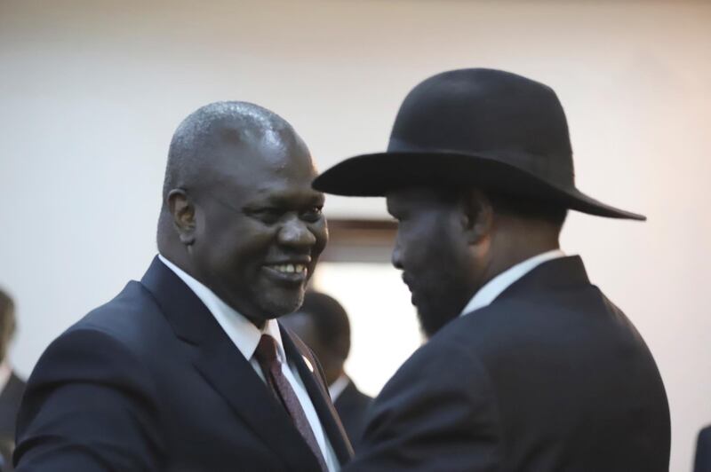 The president of South Sudan, Salva Kiir Mayardit and Riek Machar greet each other after swearing in ceremony in Juba, South Sudan. AP